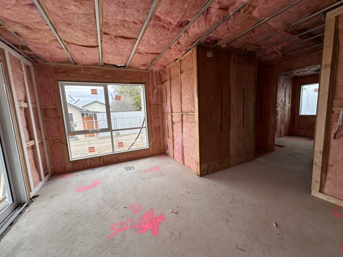 Pink Batts glasswool fitted between wall studs and ceiling joists in a new build before plaster